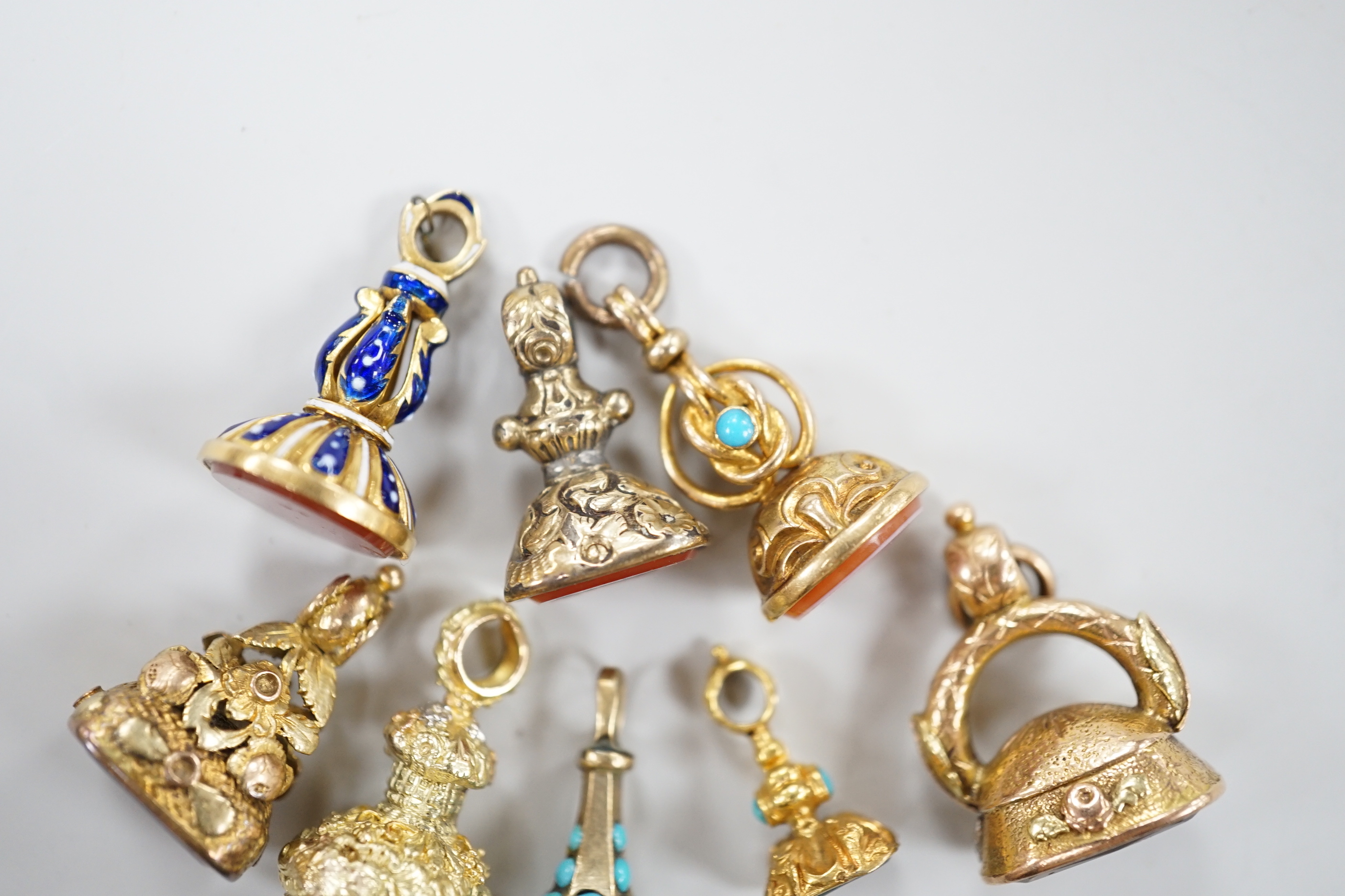 A group of eight assorted 19th century yellow metal overlaid and chalcedony or citrine set fob seals, including two colour, enamelled and turquoise set, largest 20mm.